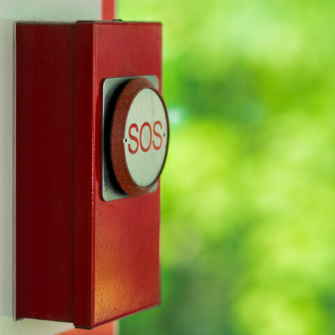 Old red emergency sos button in Kuala Lumpur park.